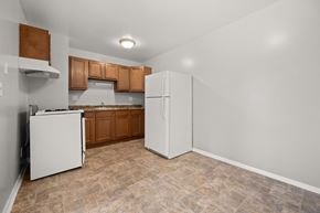 Dekalb apartment for rent - an empty kitchen with white appliances and wood cabinets