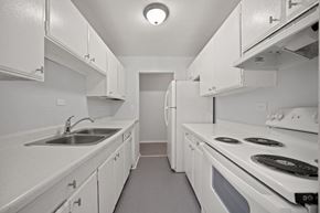 Dekalb apartment for rent - a kitchen with white appliances and white cabinets and a sink