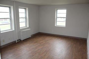 Syracuse apartment for rent - A room with wood floors and two windows.