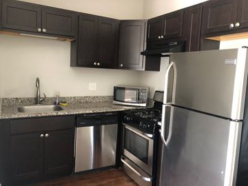 Chicago apartment for rent - a kitchen with stainless steel appliances and black cabinets