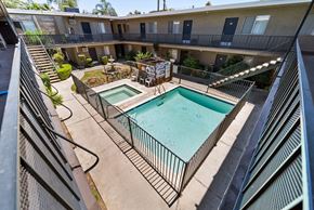 Van Nuys apartment for rent - A pool in a courtyard surrounded by a fence.