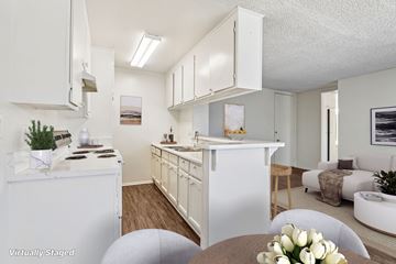 Los Angeles apartment for rent - A white kitchen with a table and chairs in the foreground.