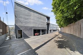 Valley Village apartment for rent - A grey building with a red car in the garage.