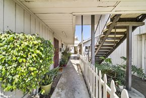 N. Hollywood apartment for rent - A long, narrow hallway with a white picket fence and a staircase on the right.