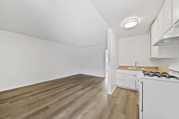 Van Nuys apartment for rent - A kitchen with a white stove and wooden floors.