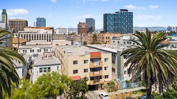 Los Angeles apartment for rent - A cityscape with buildings and palm trees.
