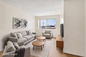 Los Angeles apartment for rent - A living room with a grey couch, a coffee table, and a television.