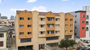 Los Angeles apartment for rent - A large building with a yellow and orange facade.