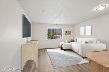 North Hills apartment for rent - A living room with a white couch and a wooden cabinet.