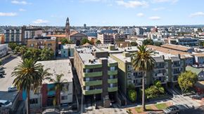 Los Angeles apartment for rent - A cityscape with buildings and palm trees.
