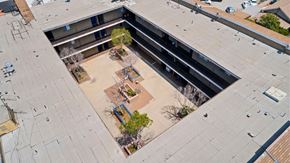 Los Angeles apartment for rent - A courtyard with a tree and a bench is surrounded by buildings.