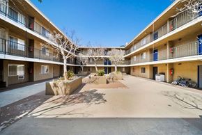 Los Angeles apartment for rent - A courtyard with a bench and a tree in the middle of it.