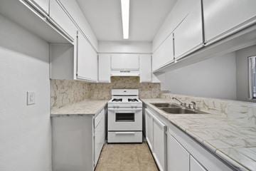 Los Angeles apartment for rent - A kitchen with white cabinets and a marble countertop.