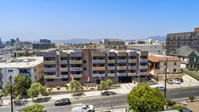 Los Angeles apartment for rent - A view of a city street with cars and buildings.