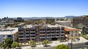 Los Angeles apartment for rent - A large apartment complex is surrounded by buildings and trees.
