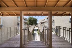 Pasadena apartment for rent - A wooden staircase with metal railings leads up to a building.