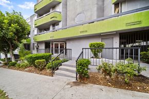 Los Angeles apartment for rent - A modern building with a green trim and a black railing on the stairs.