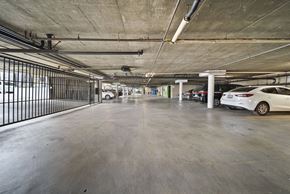 Los Angeles apartment for rent - A spacious parking garage with a white car parked on the right side.