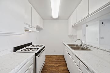 Los Angeles apartment for rent - A white kitchen with a stove, sink and cabinets.