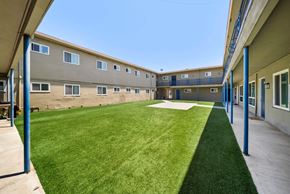 Hawthorne apartment for rent - A grassy courtyard is surrounded by apartment buildings.