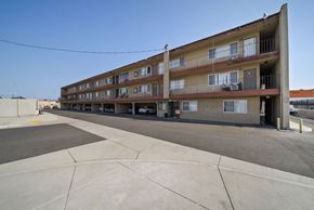 Pico Rivera apartment for rent - A large apartment complex with a parking lot in front.