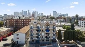Los Angeles apartment for rent - A building with a balcony in front of a city skyline.