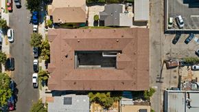 Los Angeles apartment for rent - A building with a large window is surrounded by cars and other buildings.