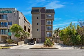 Los Angeles apartment for rent - A modern apartment building named South Towers is shown with a clear blue sky in the background.