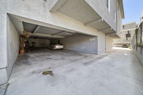 Los Angeles apartment for rent - A concrete garage with a white car inside.