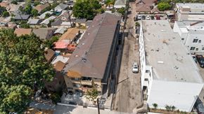 Los Angeles apartment for rent - A parking lot is in front of a building with a brown roof.
