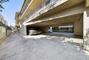 Los Angeles apartment for rent - A car is parked in a garage under a concrete building.