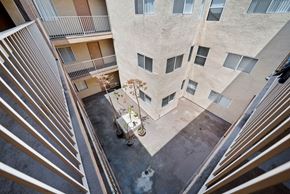 Los Angeles apartment for rent - A balcony of a building with a potted plant on it.