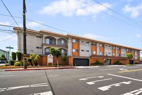 Hawthorne apartment for rent - A street view of a building with a red and white sign in front of it.