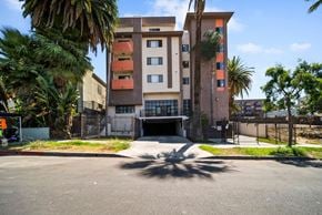 Los Angeles apartment for rent - A multi-story building with a parking lot in front.