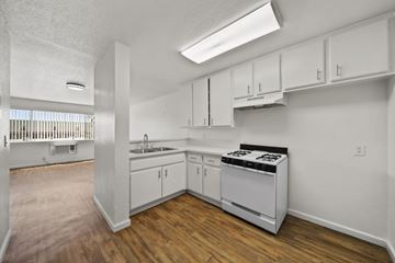 Los Angeles apartment for rent - A kitchen with white cabinets and a stove top oven.