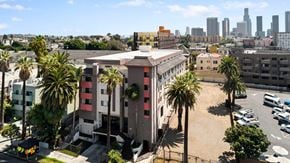 Los Angeles apartment for rent - A building with a red and white striped facade is surrounded by palm trees.
