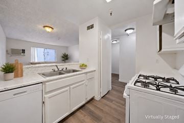 North Hills apartment for rent - A kitchen with white cabinets and a stove top oven.