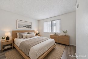 Van Nuys apartment for rent - A bedroom with a large bed, a nightstand, and a framed picture on the wall.