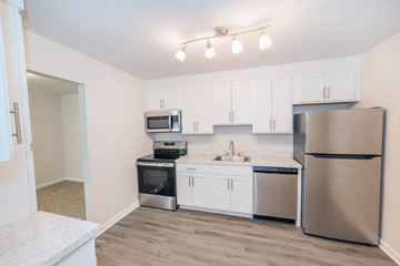 Camillus townhouse for rent - A kitchen with white cabinets and stainless steel appliances.