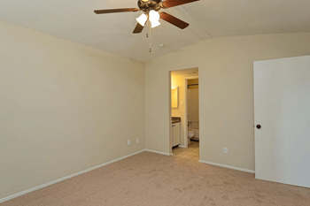 A empty living room with a ceiling fan