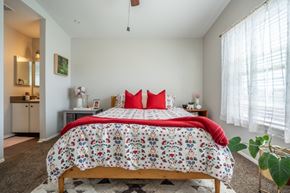 El Paso apartment for rent - A bedroom with a large bed and a red pillow.