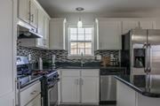 El Paso apartment for rent - a kitchen with white cabinets and black countertops and splash guards at Village of Cottonwood Springs