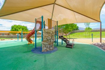 A playground with a slide and other play equipment under a tent