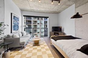 Chicago apartment for rent - A modern bedroom with a large bed and a couch.