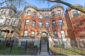 Chicago apartment for rent - A large, red brick Victorian style house with a black iron fence.