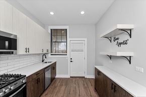 Chicago apartment for rent - A modern kitchen with a white countertop and wooden cabinets.