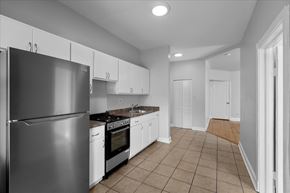 Chicago apartment for rent - A kitchen with a refrigerator, oven, and cabinets.