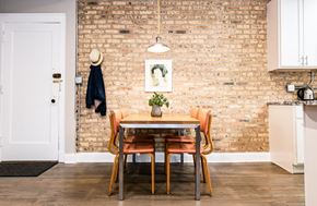 Chicago apartment for rent - A dining room with a brick wall and a table with chairs.