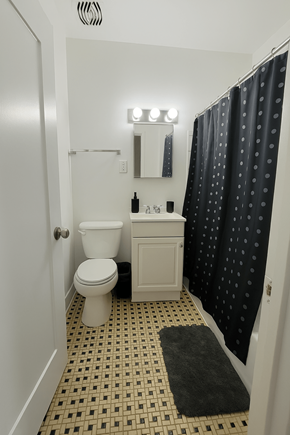 Chicago apartment for rent - A small bathroom with a toilet, sink, and shower curtain.