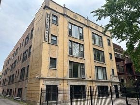 Chicago apartment for rent - A tall brick building with a sign on the side.